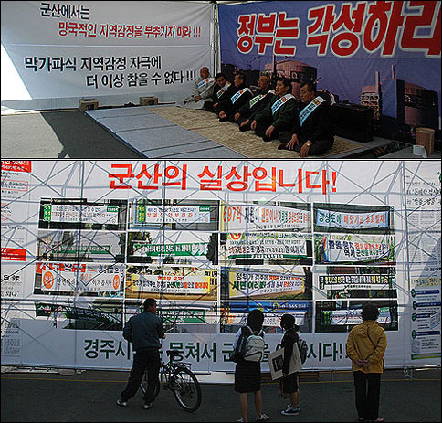 경주역 광장에서 삭발단식농성을 벌이고 있는 경주시장과 시의회 의장(위), 이들의 농성장 바로 옆에는 지역감정을 유발하는 군산지역의 펼침막을 찍은 대형 걸개판이 설치돼 있다.(아래) 